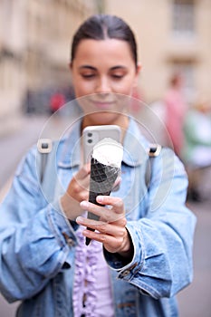 Young Woman Taking Photo Of Ice Cream Cone With Mobile Phone To Post On Social Media