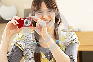 Young Woman Taking Photograph On Digital Camera