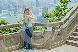 Young woman taking photos of victoria harbor in Hong Kong, China