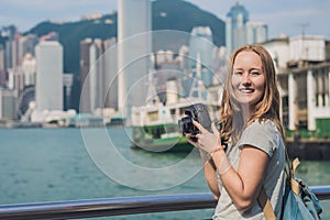 Young woman taking photos of victoria harbor in Hong Kong, China