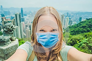 Young woman taking photos of victoria harbor in Hong Kong, China Tourists fear the 2019-ncov virus. Medical masked