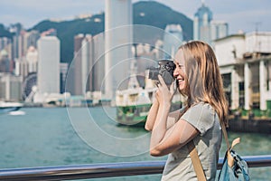 Young woman taking photos of victoria harbor in Hong Kong, China