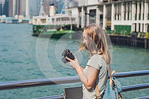 Young woman taking photos of victoria harbor in Hong Kong, China