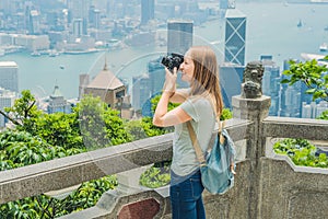 Young woman taking photos of victoria harbor in Hong Kong, China