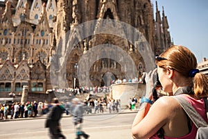 Young woman taking picture of Sagrada Familia, Barcelona, Spain photo