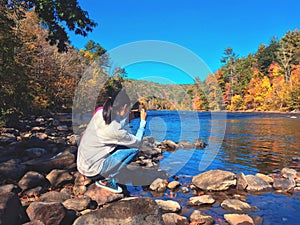 A young woman taking pictures of the autumn views