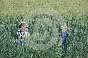 Young woman taking pictures of a child in a field