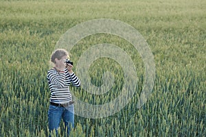 Young woman taking pictures of a child in a field