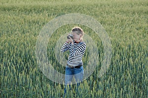 Young woman taking pictures of a child in a field