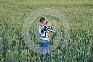 Young woman taking pictures of a child in a field