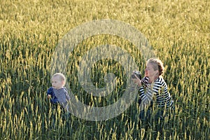 Young woman taking pictures of a child in a field