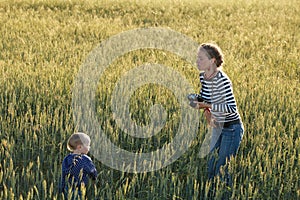 Young woman taking pictures of a child in a field