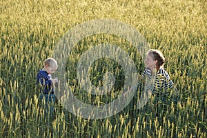 Young woman taking pictures of a child in a field