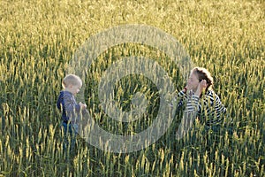 Young woman taking pictures of a child in a field