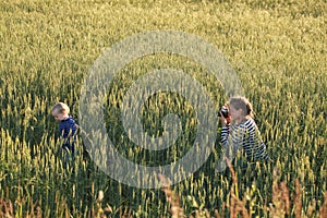 Young woman taking pictures of a child in a field