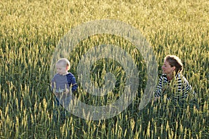 Young woman taking pictures of a child in a field