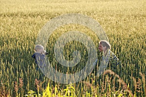 Young woman taking pictures of a child in a field