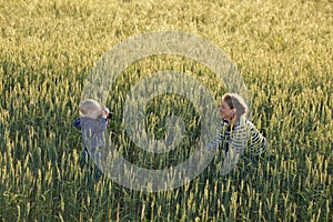 Young woman taking pictures of a child in a field