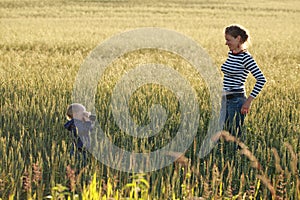 Young woman taking pictures of a child in a field