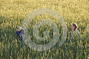 Young woman taking pictures of a child in a field