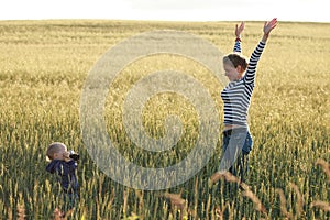 Young woman taking pictures of a child in a field