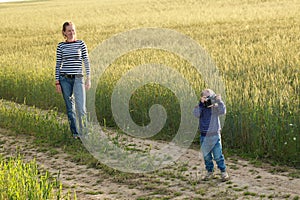 Young woman taking pictures of a child field