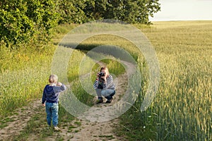 Young woman taking pictures of a child field