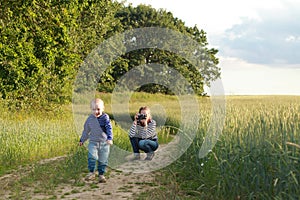 Young woman taking pictures of a child field