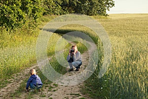 Young woman taking pictures of a child field