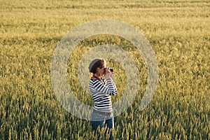 Young woman taking pictures of a child in a field