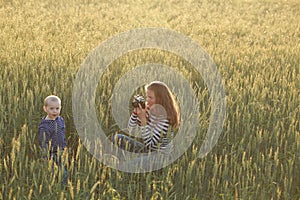 Young woman taking pictures of a child in a field