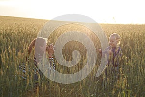 Young woman taking pictures of a child in a field