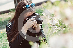 Young woman taking pictures of flowering trees