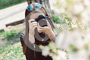 Young woman taking pictures of flowering trees