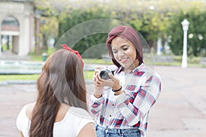 Young woman taking pictures of her friends in the park.