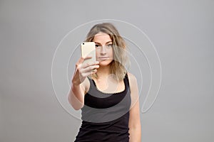 Young woman taking pictures through her phone