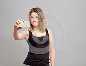 Young woman taking pictures through her phone