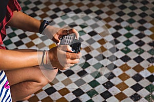 young woman taking pictures of moroccan mosaic in bahia palace - Marrakech, Morocco