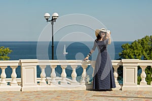 Young woman taking pictures on a smart phone on the waterfront n