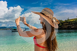 Young woman taking pictures in a sunny day during summer vacation