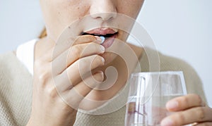 Young woman taking a pill