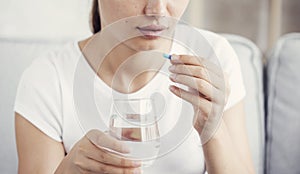 Young woman taking pill