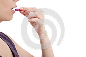 Young woman taking pill over white background