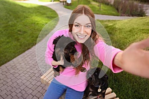 Young woman taking selfie with adorable Brussels Griffon dogs