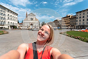 Young woman taking a selfie against the background of Church of Santa Maria Novella in Florence