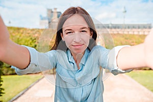 Young woman taking selfie with mobile phone outdoors in Paris