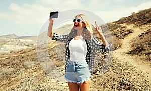 young woman taking selfie picture by smartphone on a hiking trail on top of the mountain, Tenerife, Canary Islands