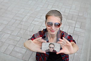 Young woman taking selfie picture by smartphone over city street background