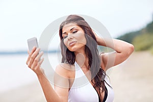 Young woman taking selfie with smartphone