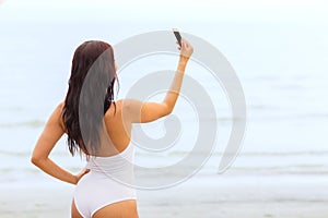 Young woman taking selfie with smartphone